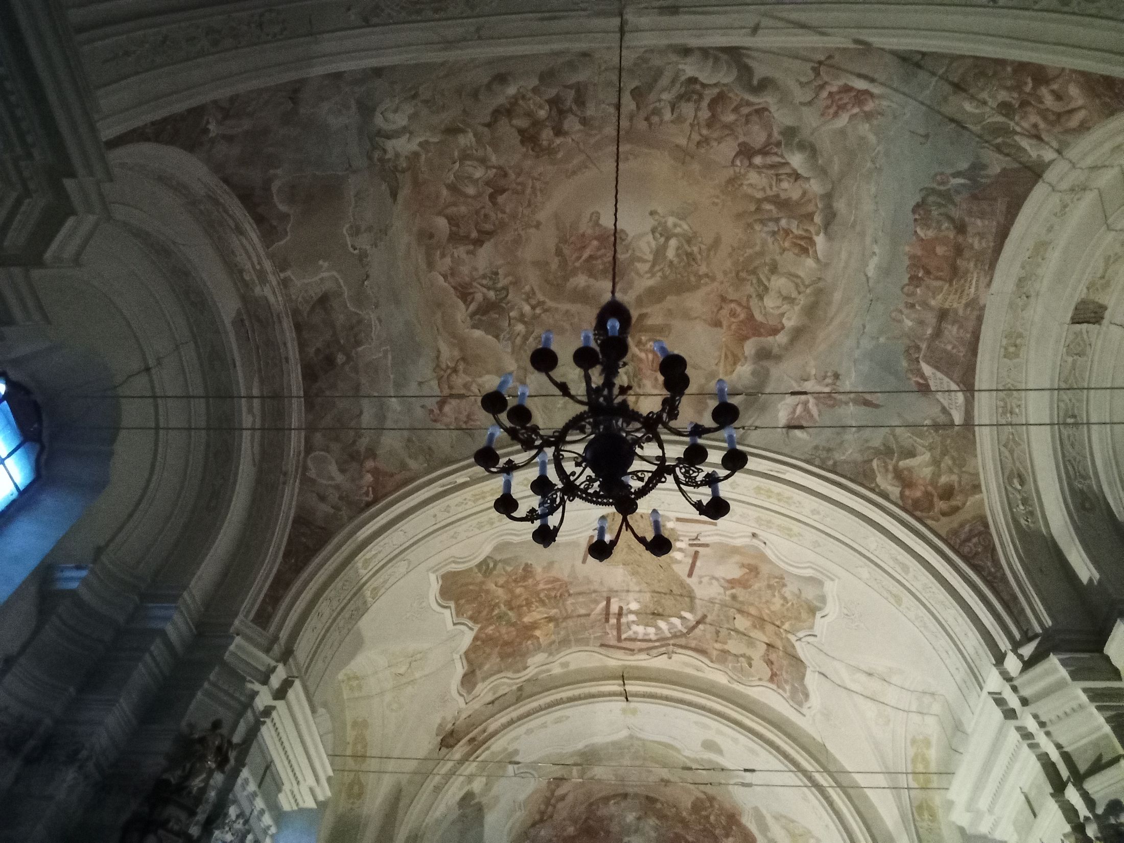 Detail stropní klenby s ozdobným lustrem.